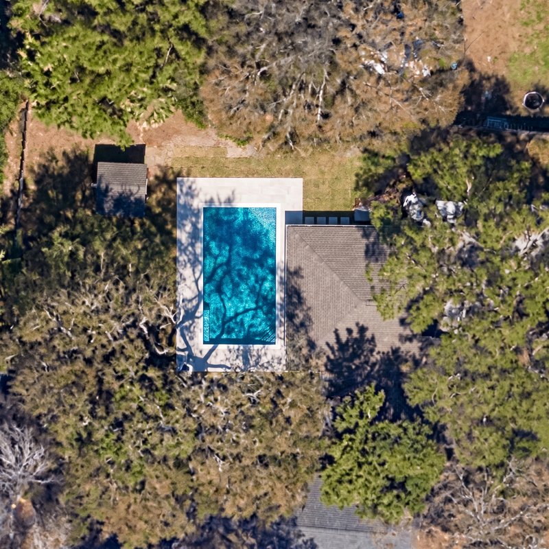 The same backyard with the pool the homeowner designed in chat, rendered onto the satellite image