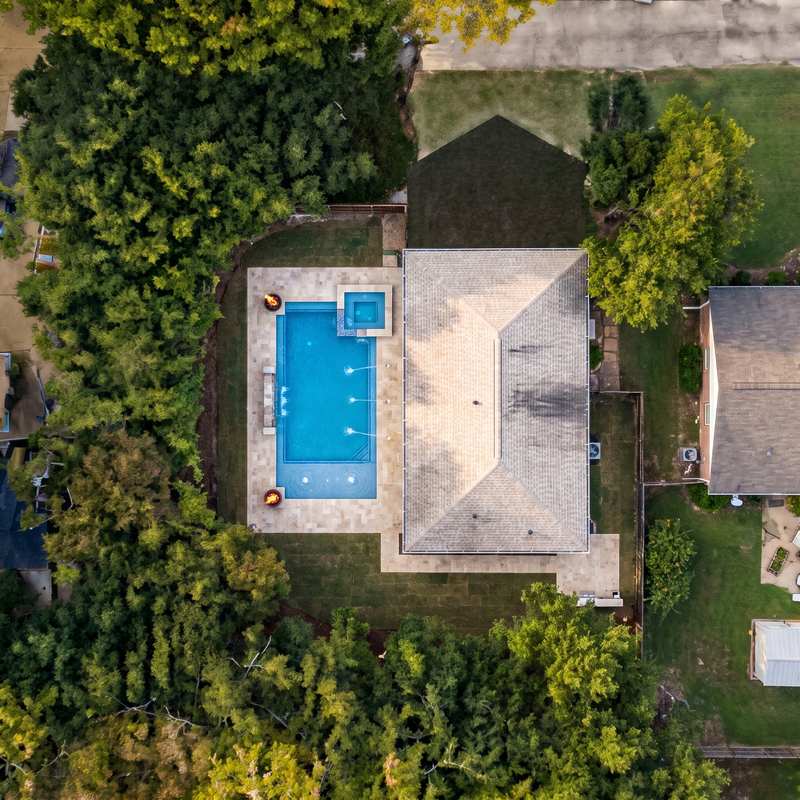 The same backyard with the pool the homeowner designed in chat, rendered onto the satellite image