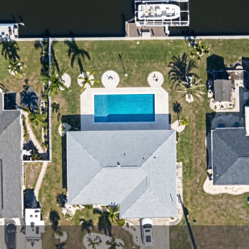 The same backyard with the pool the homeowner designed in chat, rendered onto the satellite image
